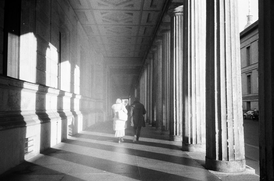 Silhouette of a person walking alone through a museum corridor